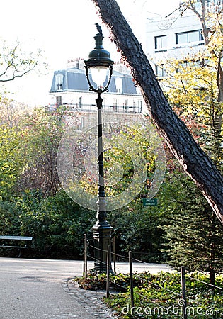 Historical street light in traditional Paris park with Haussmann buildings Stock Photo