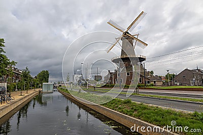 Historical wind mill by a canal in Delft , the Netherlands Editorial Stock Photo