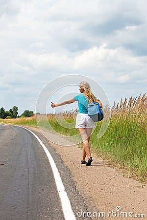 Hitchhiking girl votes on road Stock Photo