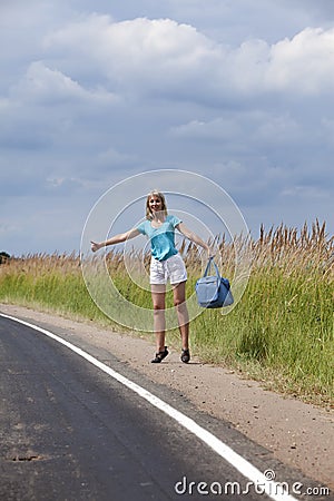 Hitchhiking girl votes on road Stock Photo