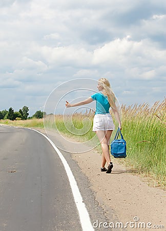 Hitchhiking girl votes on road Stock Photo