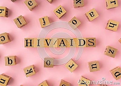 HIV AIDS word on wooden block. Flat lay view on light pink background Stock Photo
