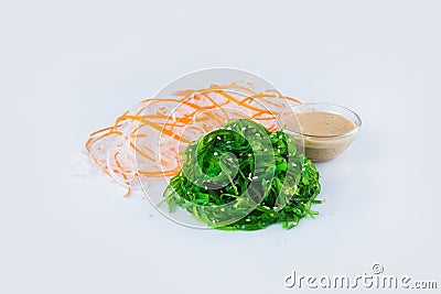 Hiyashi Wakame Chuka seaweed salad with sesame seeds isolated, served with celery and carrot slices isolated on background Stock Photo