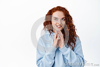 Hmm interesting idea. Smiling cunning redhead girl have plan, steeple fingers and look away thoughtful, scheming, have Stock Photo