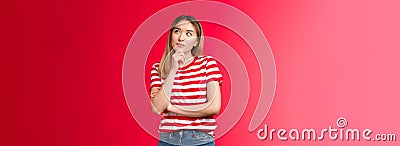 Hmm maybe. Girl pondering interesting idea, thinking touch chin thoughtful, look up smiling delighted, have interesting Stock Photo