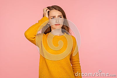 Hmm, need to think. Portrait of pensive ginger girl in sweater scratching head and pondering idea, contemplating how solve problem Stock Photo