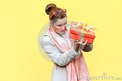 Hmm what is it! Cunning woman looking at gift box and want too o Stock Photo