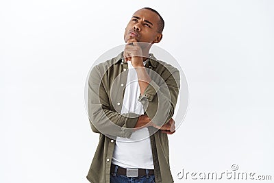 Hmmm interesting. Portrait of thoughtful handsome, smart african american man thinking, making choice, squinting and Stock Photo