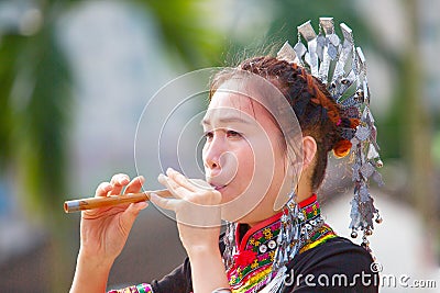 The Hmong women on their traditional dresses is playing their own music instrument Stock Photo