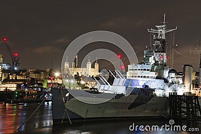 HMS Belfast with Tower of London at night Stock Photo
