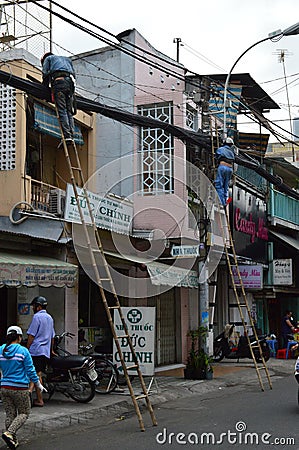 Men working at height on bamboo ladders Ho Chi Min City Vietnam Editorial Stock Photo