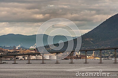 Hobart, Tasmania, Australia - December 13. 2009: Tasman highway bridge over Derwent River with mountains and white petroleum tanks Stock Photo