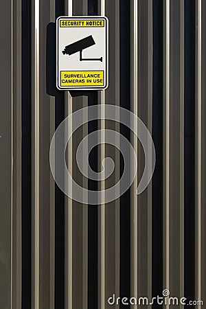 Sign attached to a building exterior wall indicating surveillance cameras are operating Editorial Stock Photo