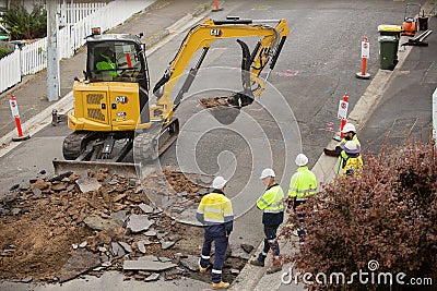 Machinery and workers repairing street surface Editorial Stock Photo