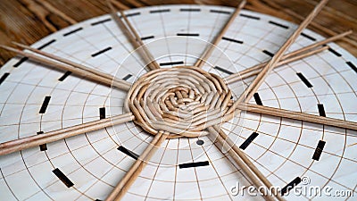 Hobbies and craft concept. Initial process weaving of circle bottom of a basket of tubes twisted from paper. Wicker Stock Photo