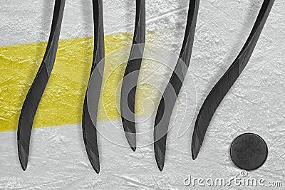 Five hockey sticks, puck and yellow stripe Stock Photo