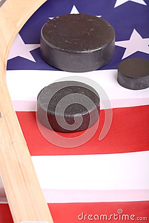 Hockey equipment including a stick and puck on an American flag to infer a patriotic American sport. Stock Photo