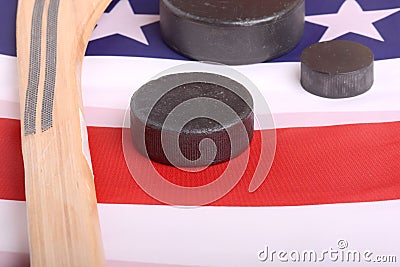 Hockey equipment including a stick and puck on an American flag to infer a patriotic American sport. Stock Photo