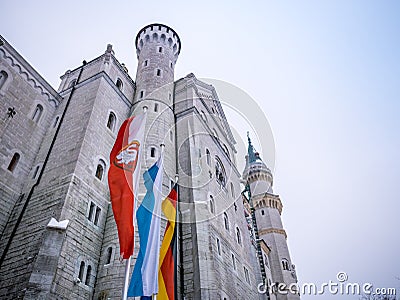 HOHENSCHWANGAU, GERMANY - 23 FEBUARY 2018: Neuschwanstein Castle in winter Close-up. Germany and EU flag.The destination famous ca Editorial Stock Photo