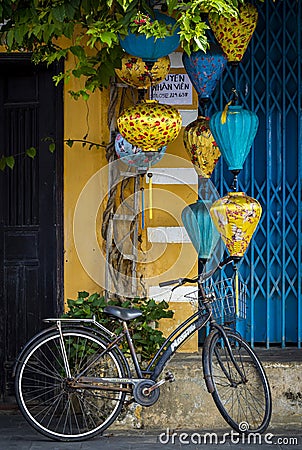 Street view of a blue door with yellow lanterns and a bike in Vietnam Hoi An old town Editorial Stock Photo