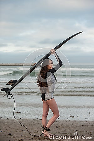 Hoisting the board up at the beach. Stock Photo