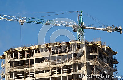 Hoisting tower crane abov top of building house Stock Photo