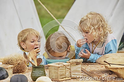 Hojbjerg, Denmark, July 29, 2023: Children eat at the Viking Festival Editorial Stock Photo