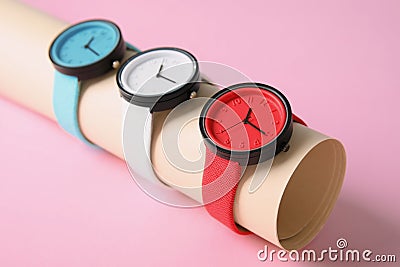 Holder with collection of stylish wrist watches on color background. Stock Photo