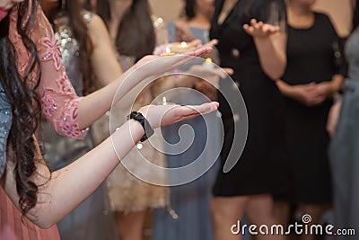 Holding hands on henna candle . She holds the candle in his hand Henna party Stock Photo