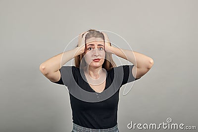 Holding her head with both of hands can not believe shocked, being in panic, Stock Photo