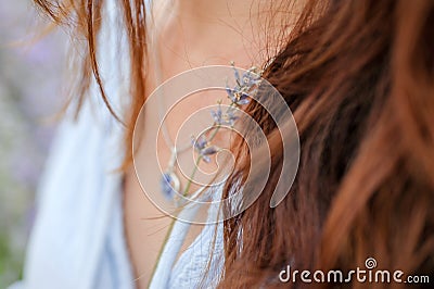 Holding lavender flower, focus on flower hair and fragment of shirt Stock Photo