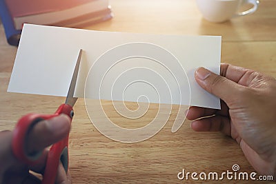 Holding scissors and cutting blank white paper Stock Photo