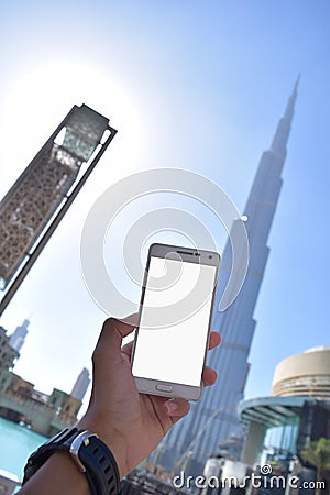 Holding white phone with Burj Khalifah Background Stock Photo