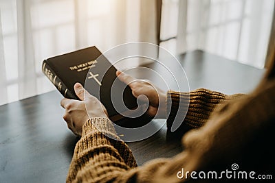 holds bible in hands. Reading the Holy Bible in home. Concept for faith, spirituality and religion. Peace, hope Stock Photo