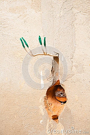 Hole in the wall for AC power socket Stock Photo