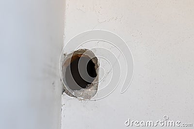 Holes on the cement wall Caused by drilling. hole in in white cement wall as a background. Hole on the wall. Stock Photo