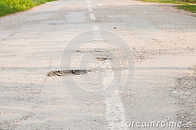 Holes on the road. dangerous pothole in the asphalt highway.Outdoor Stock Photo