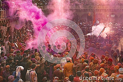 Shower of colours with Sun beam on the devotees of Lord Krishna at Nand Baba temple, Nandgaon, India Editorial Stock Photo