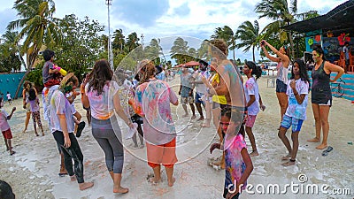 CLOSE UP: Tourists and locals dance the in rain during hindu festival of colors Editorial Stock Photo