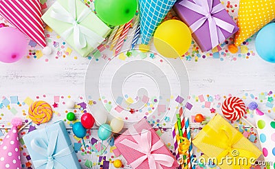 Holiday background with balloons, gift boxes and confetti. Birthday and party supplies on white table top view. Banner format Stock Photo