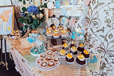 Holiday candy bar. Cupcakes with cream and fruits and blue and white cake pops decorated with paper hearts on wedd candy bar Stock Photo