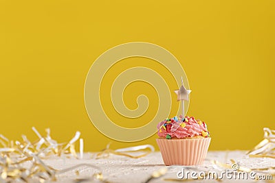 Holiday card with cupcake with candles on bright yellow background and place for your text Stock Photo