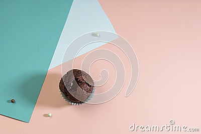 Holiday concept. Delicious homemade chocolate muffin with sweets on a pink and blue background. Geometric trend. Creative Stock Photo
