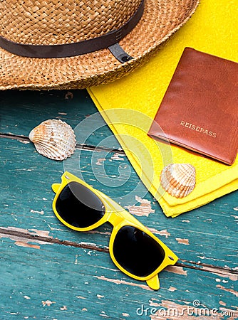 Holiday Concept: Vintage wood table with holiday accessories: Straw hat, sunglasses, shells, vintage camera and bath towel Stock Photo