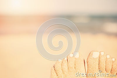 Holiday concept. Woman feet close-up relaxing on beach, enjoying sun and splendid view. Sandy feet on the beach. Sun, sun haze Stock Photo