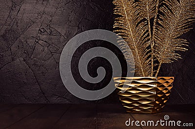 Holiday dark interior in vintage style with decorative golden warm branch in glossy modern bowl on wood board, black plaster wall. Stock Photo