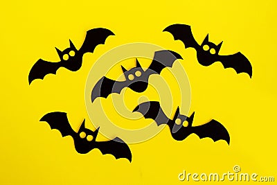 Holiday decorations for Halloween. Five black paper bats on a yellow background, top view Stock Photo