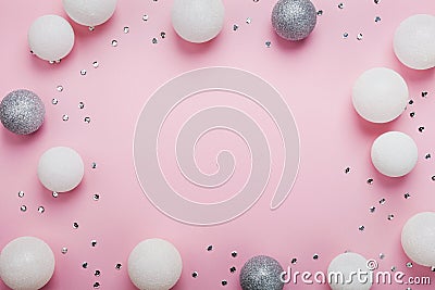Holiday frame made of christmas balls and sequins on stylish pink table top view. Fashion background. Flat lay. Party mockup. Stock Photo