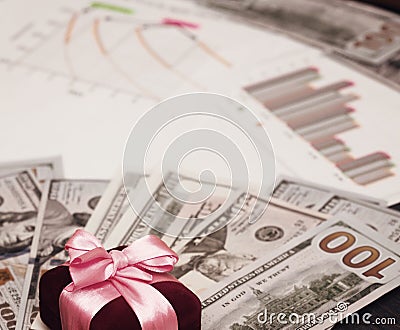 A holiday gift of money. Dollar billboards with a red satin ribbon and a box. Stock Photo