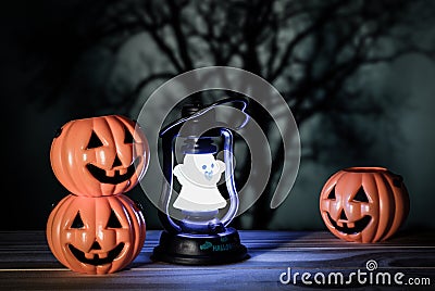 Holiday halloween with three toys pumpkin, toy lantern ghost on wooden table, horizontal horror background and voodoo tone. Stock Photo